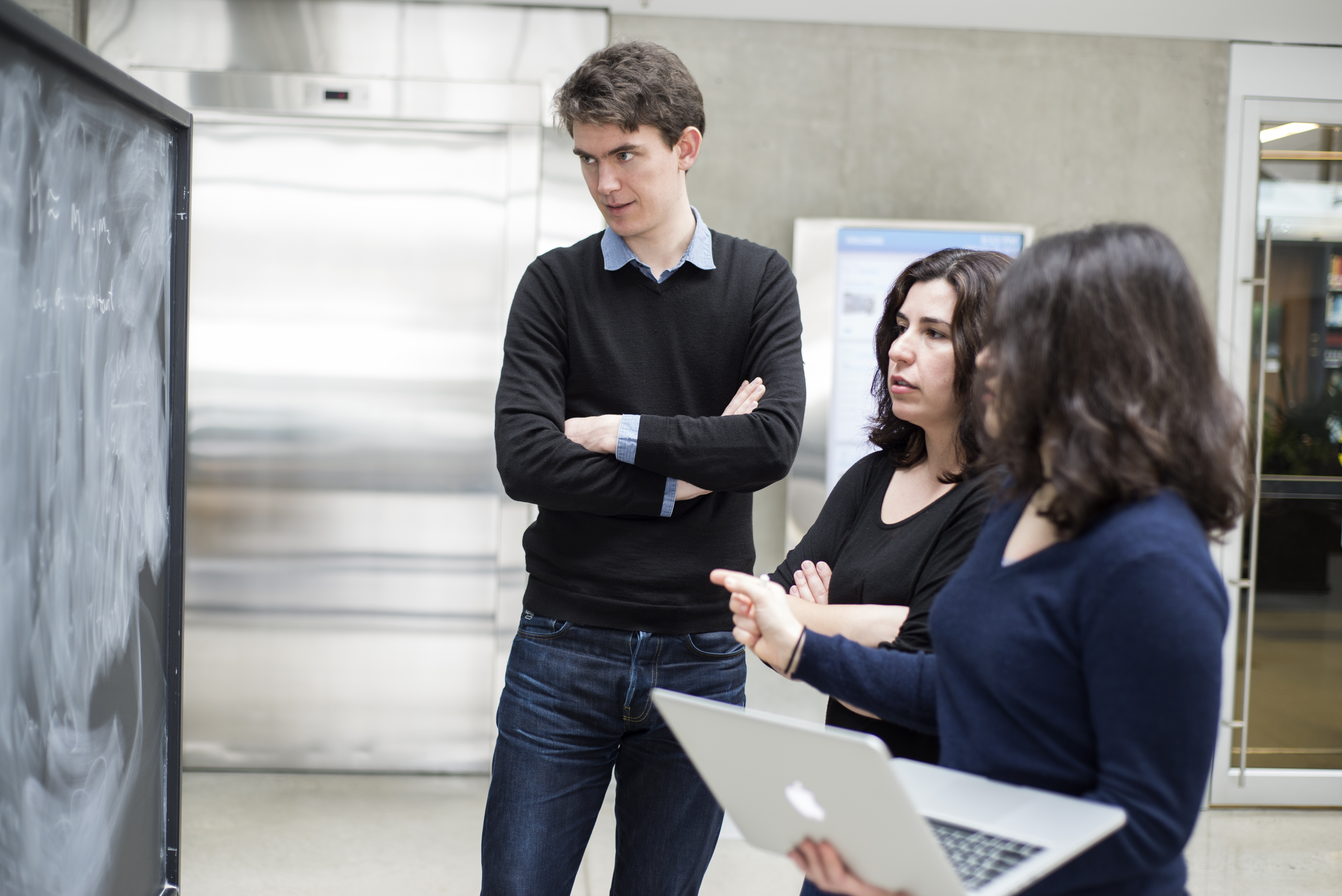 Asimina Arvanitaki, Masha Baryakhtar and Robert Lasenby collaborating on a blackboard in the Atrium